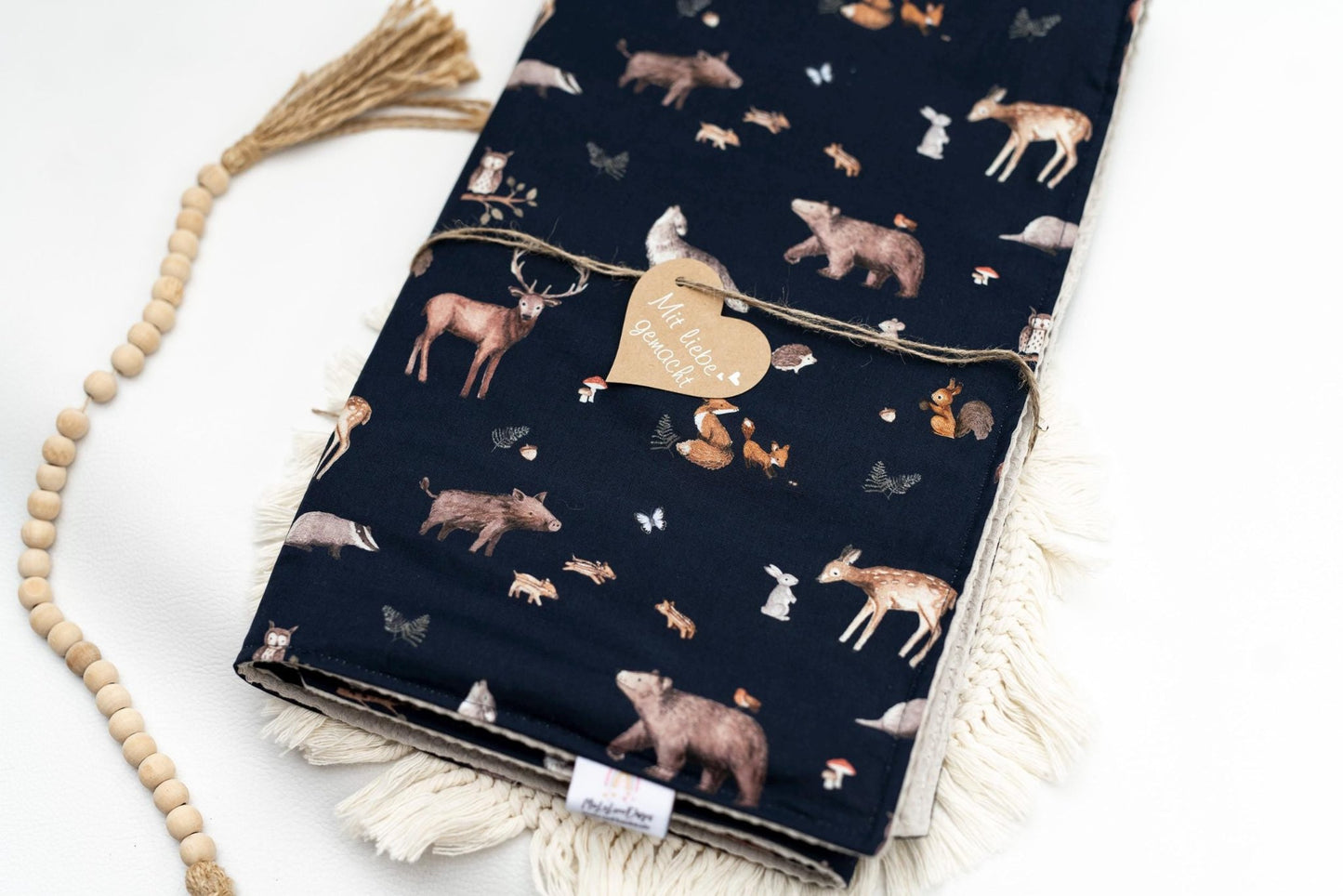 Kuschelige Babydecke aus 100% Baumwolle. Die obere Seite is aus einem Satinbaumwollstoff in Navy mit Waldtiermotiven. Die untere Seite ist ein Waffelbaumwollstoff in beige.