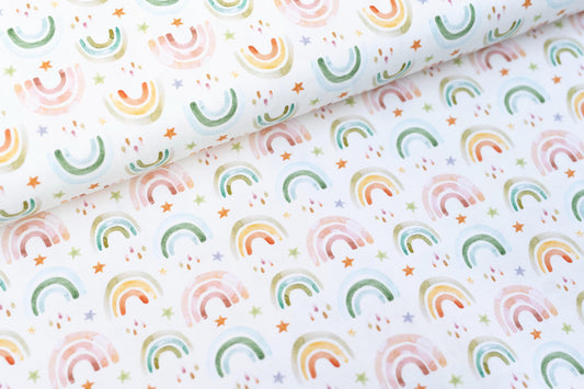 Jerseystoff in weiß mit süßen farbigen Regenbögen als Motiv.